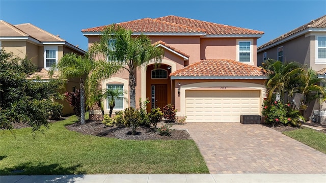 mediterranean / spanish-style home with a front yard and a garage