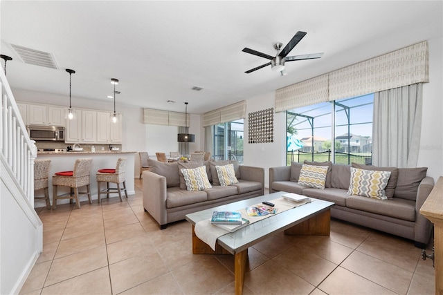 living room with ceiling fan and light tile patterned floors