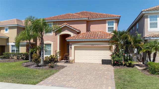 mediterranean / spanish house with a garage and a front lawn