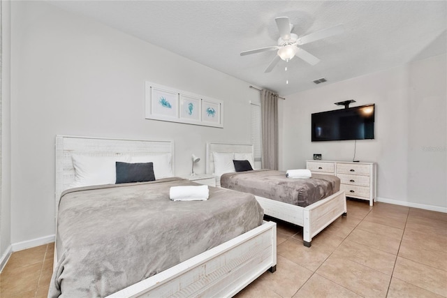 bedroom featuring ceiling fan, tile patterned flooring, and a textured ceiling