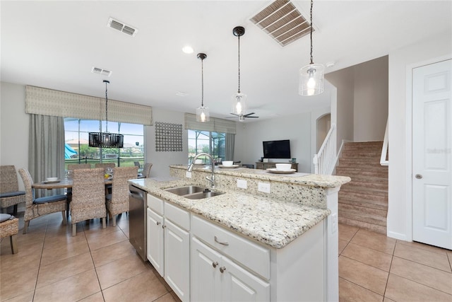 kitchen featuring white cabinetry, sink, stainless steel dishwasher, decorative light fixtures, and a center island with sink