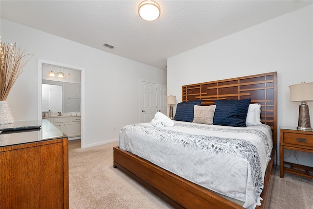 bedroom with light carpet and ensuite bath