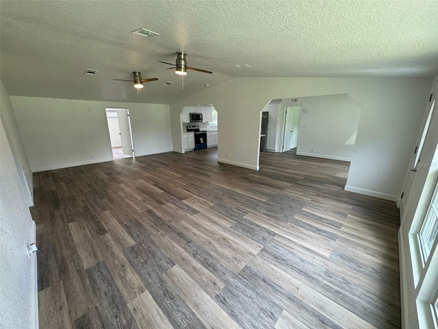 unfurnished living room featuring lofted ceiling, ceiling fan, dark wood-type flooring, and a textured ceiling