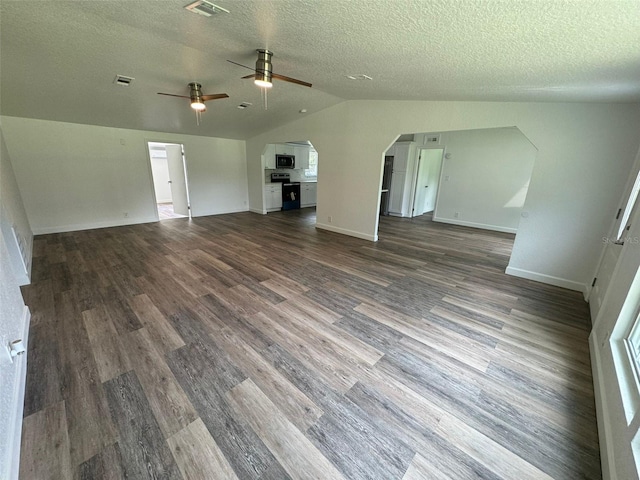 unfurnished living room featuring dark wood-type flooring, a textured ceiling, and vaulted ceiling