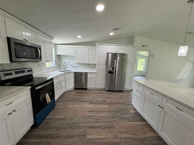 kitchen featuring white cabinetry, backsplash, decorative light fixtures, and stainless steel appliances