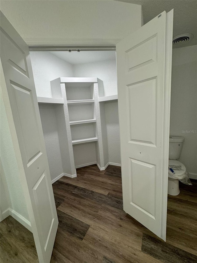 spacious closet featuring dark hardwood / wood-style flooring