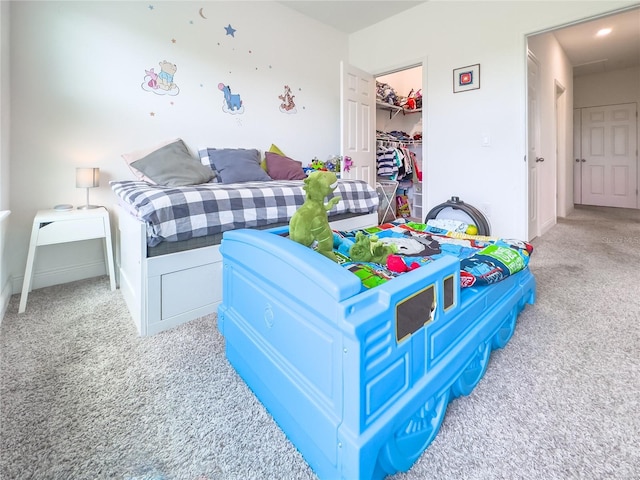 carpeted bedroom featuring a walk in closet and a closet