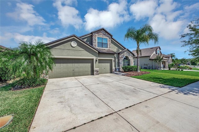 view of front of property featuring stucco siding, stone siding, concrete driveway, an attached garage, and a front yard