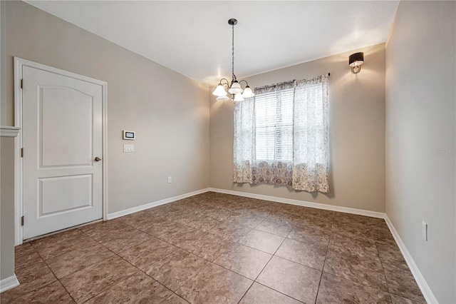 unfurnished room with a notable chandelier