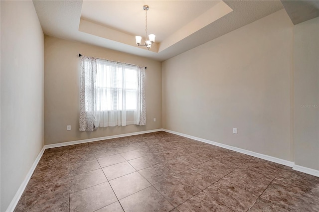 spare room with tile patterned floors, an inviting chandelier, and a raised ceiling