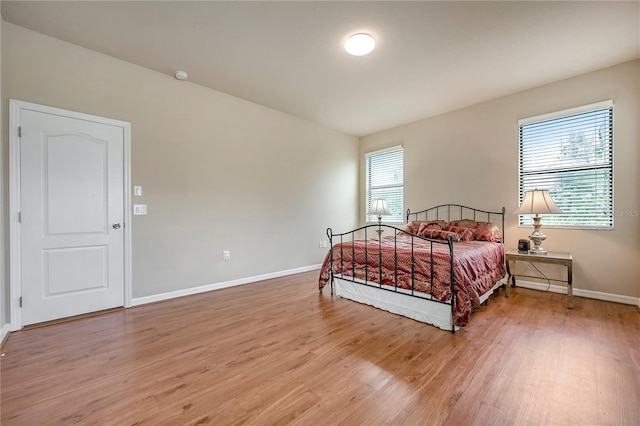 bedroom with wood-type flooring and multiple windows