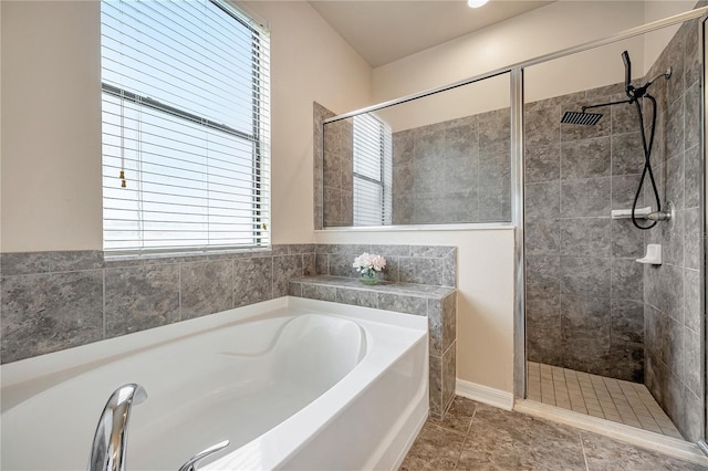 bathroom with a wealth of natural light and shower with separate bathtub