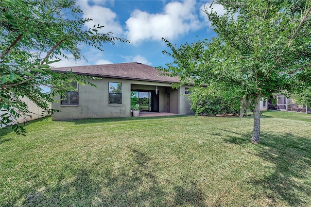 rear view of house featuring a yard