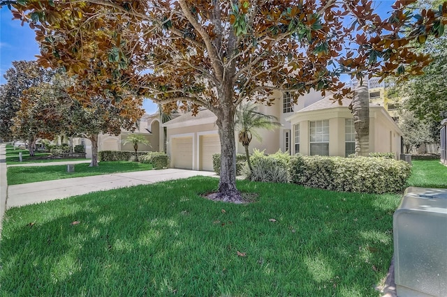 view of property hidden behind natural elements featuring a garage and a front lawn