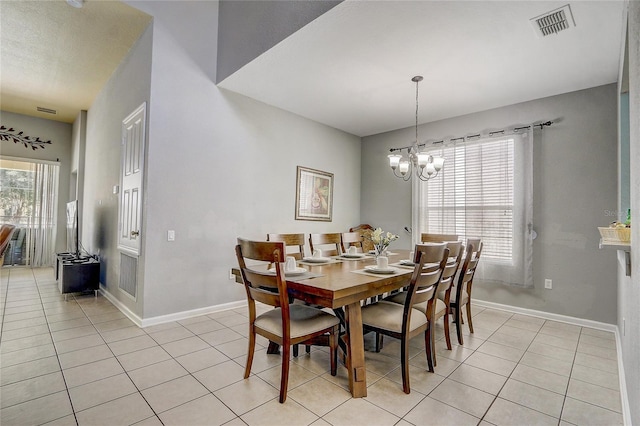 tiled dining room with a notable chandelier