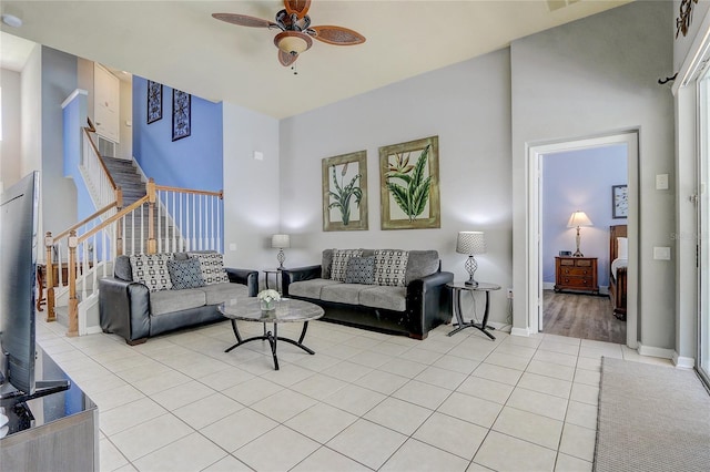 living room featuring a towering ceiling, ceiling fan, and light tile patterned flooring