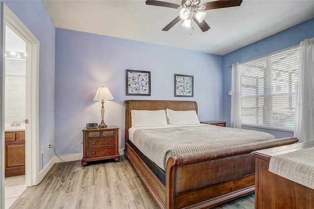 bedroom with connected bathroom, ceiling fan, light hardwood / wood-style flooring, and sink