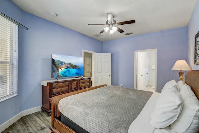 bedroom featuring ceiling fan, light wood-type flooring, and ensuite bathroom