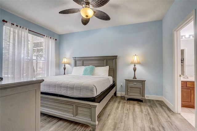 bedroom with connected bathroom, ceiling fan, and light hardwood / wood-style flooring