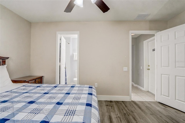 bedroom featuring connected bathroom, light hardwood / wood-style flooring, and ceiling fan