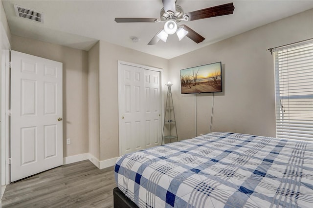 bedroom with hardwood / wood-style floors, ceiling fan, and a closet