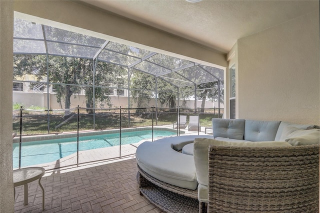 view of swimming pool featuring an outdoor living space, a lanai, and a patio area