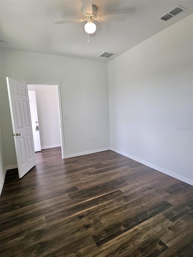 unfurnished room with dark hardwood / wood-style floors, ceiling fan, and a textured ceiling