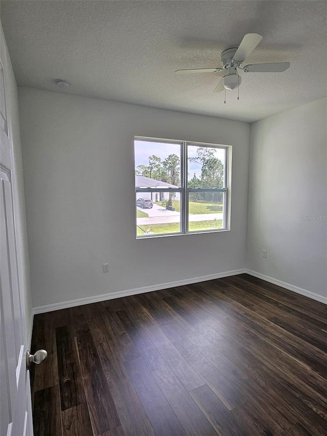 spare room featuring ceiling fan, dark hardwood / wood-style flooring, and a textured ceiling