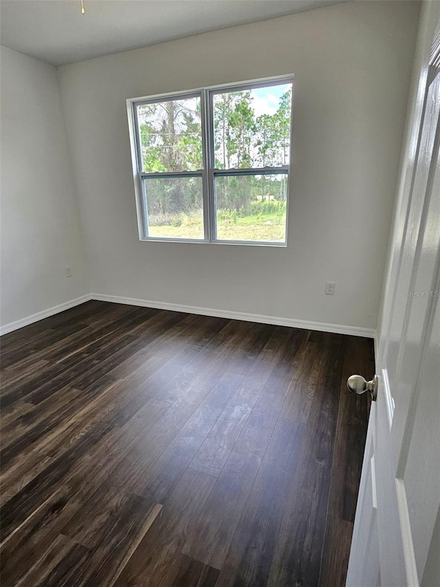 unfurnished room with plenty of natural light and dark wood-type flooring