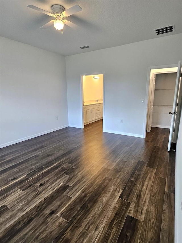 unfurnished room featuring a textured ceiling, ceiling fan, and dark wood-type flooring