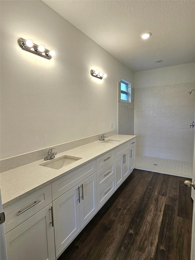 bathroom featuring a shower, vanity, a textured ceiling, and hardwood / wood-style flooring