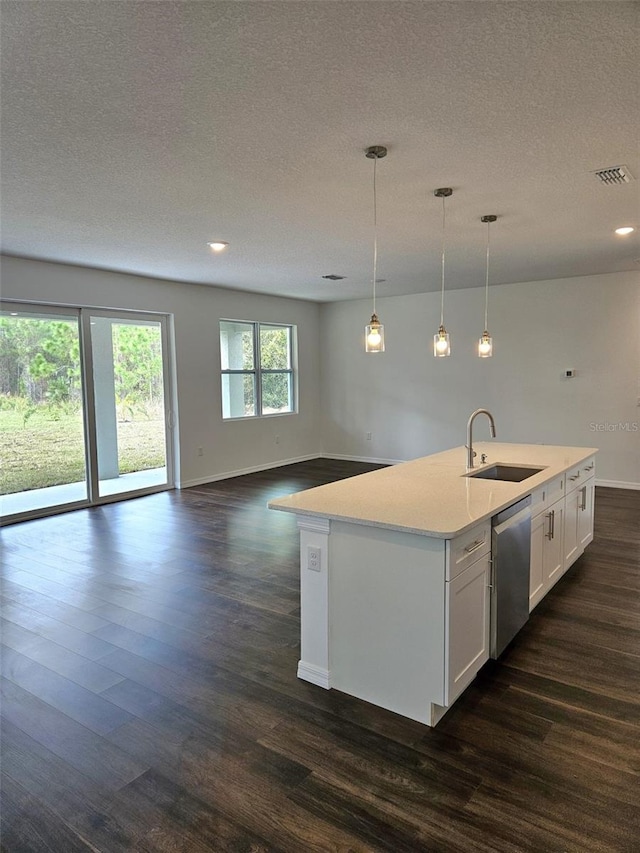 kitchen featuring a kitchen island with sink, sink, dishwasher, white cabinetry, and hanging light fixtures