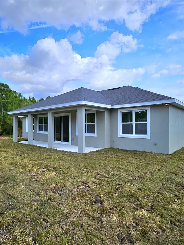 rear view of property with a patio and a lawn