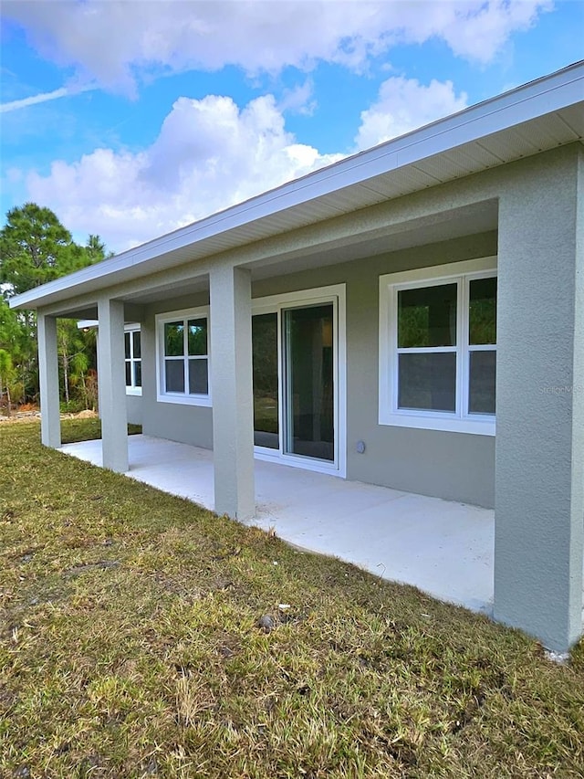 rear view of house featuring a lawn and a patio area