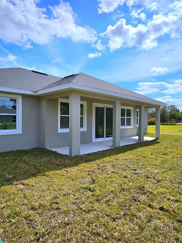 view of side of property with a patio area and a yard