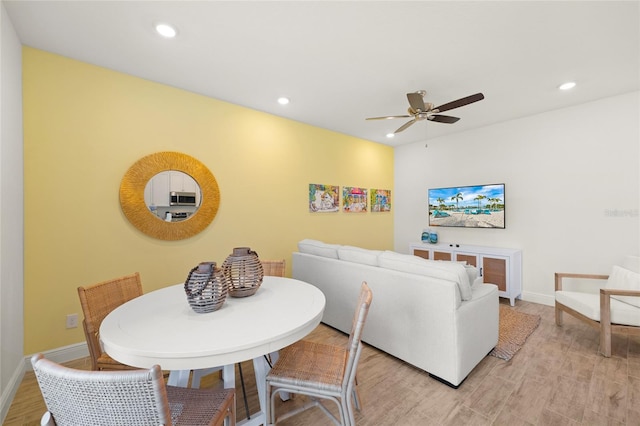 dining area with ceiling fan and light hardwood / wood-style flooring