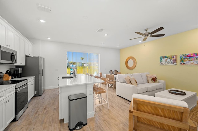 kitchen featuring white cabinets, light hardwood / wood-style floors, and stainless steel appliances