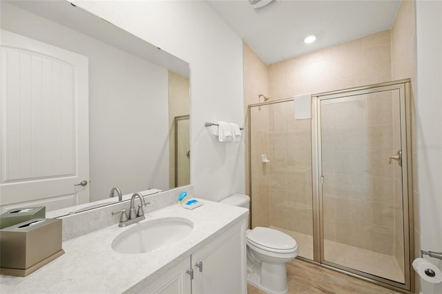 bathroom featuring vanity, toilet, and a shower with door