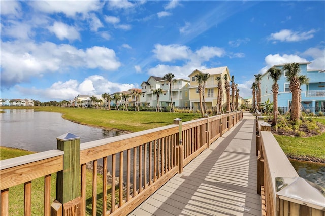 view of dock with a lawn and a water view