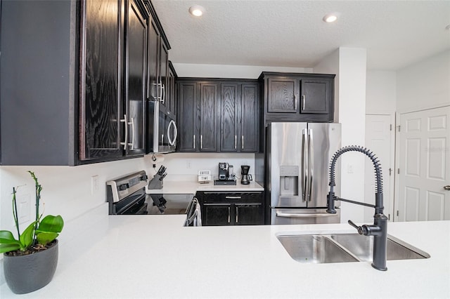 kitchen with dark brown cabinets, a textured ceiling, stainless steel appliances, and sink