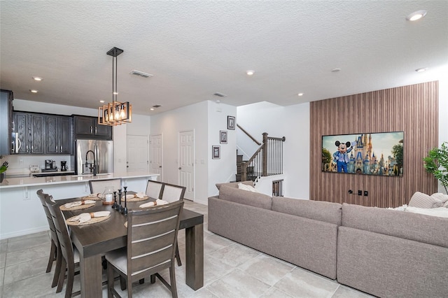 tiled dining room with a textured ceiling and sink