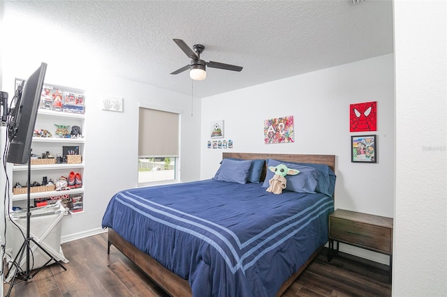 bedroom with a textured ceiling, ceiling fan, and dark wood-type flooring