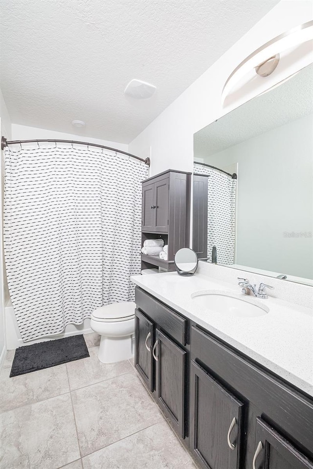 full bathroom featuring vanity, shower / bath combination with curtain, tile patterned flooring, toilet, and a textured ceiling