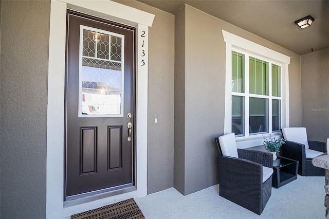 2135 Valencia Blossom St, Clermont, FL 34711 - view of exterior entry with stucco siding and a porch