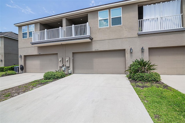 multi unit property with a balcony, a garage, and central air condition unit