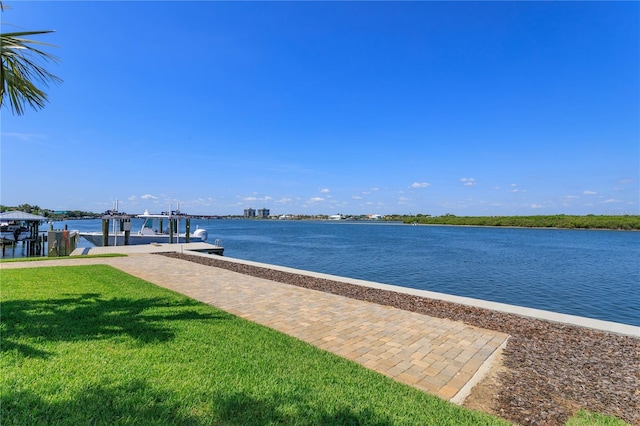 view of dock with a yard and a water view