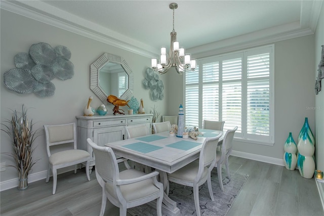 dining space with a chandelier, light wood-style floors, baseboards, and ornamental molding