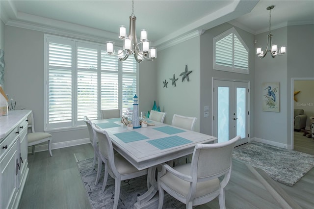 dining space with a chandelier, baseboards, french doors, crown molding, and light wood-type flooring