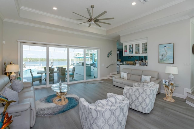 living area featuring ceiling fan, wood finished floors, baseboards, recessed lighting, and a raised ceiling