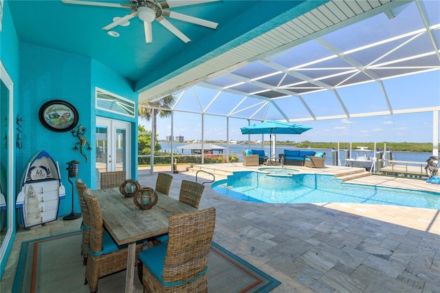 view of pool featuring a patio, ceiling fan, an outdoor living space, glass enclosure, and french doors
